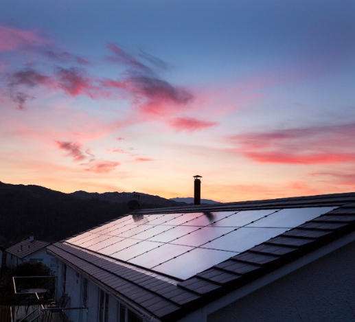 solar panels on the roof of a house during a beautiful sunset