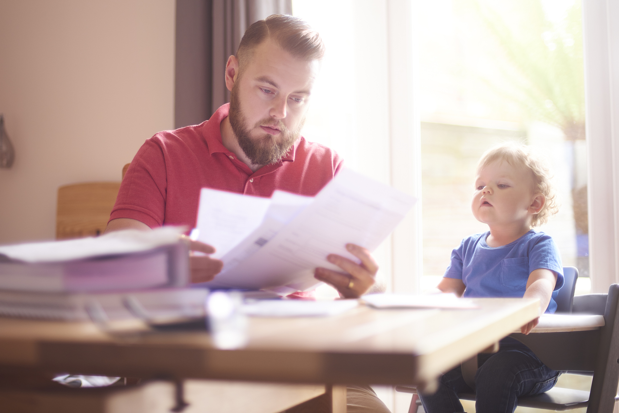 Dad with a child looking at a bill