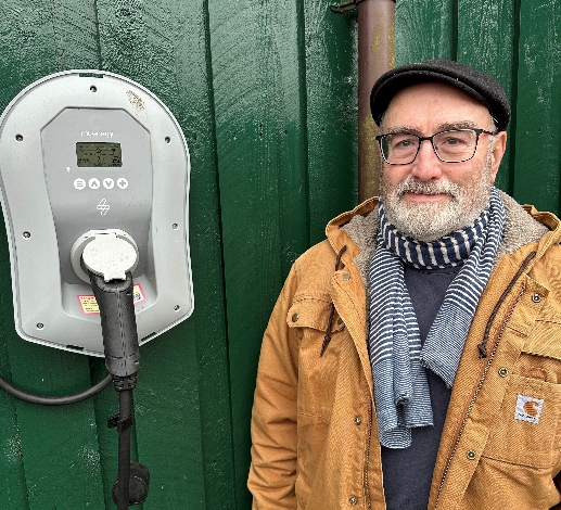 Mr Ratter stands in front of his electric vehicle charger