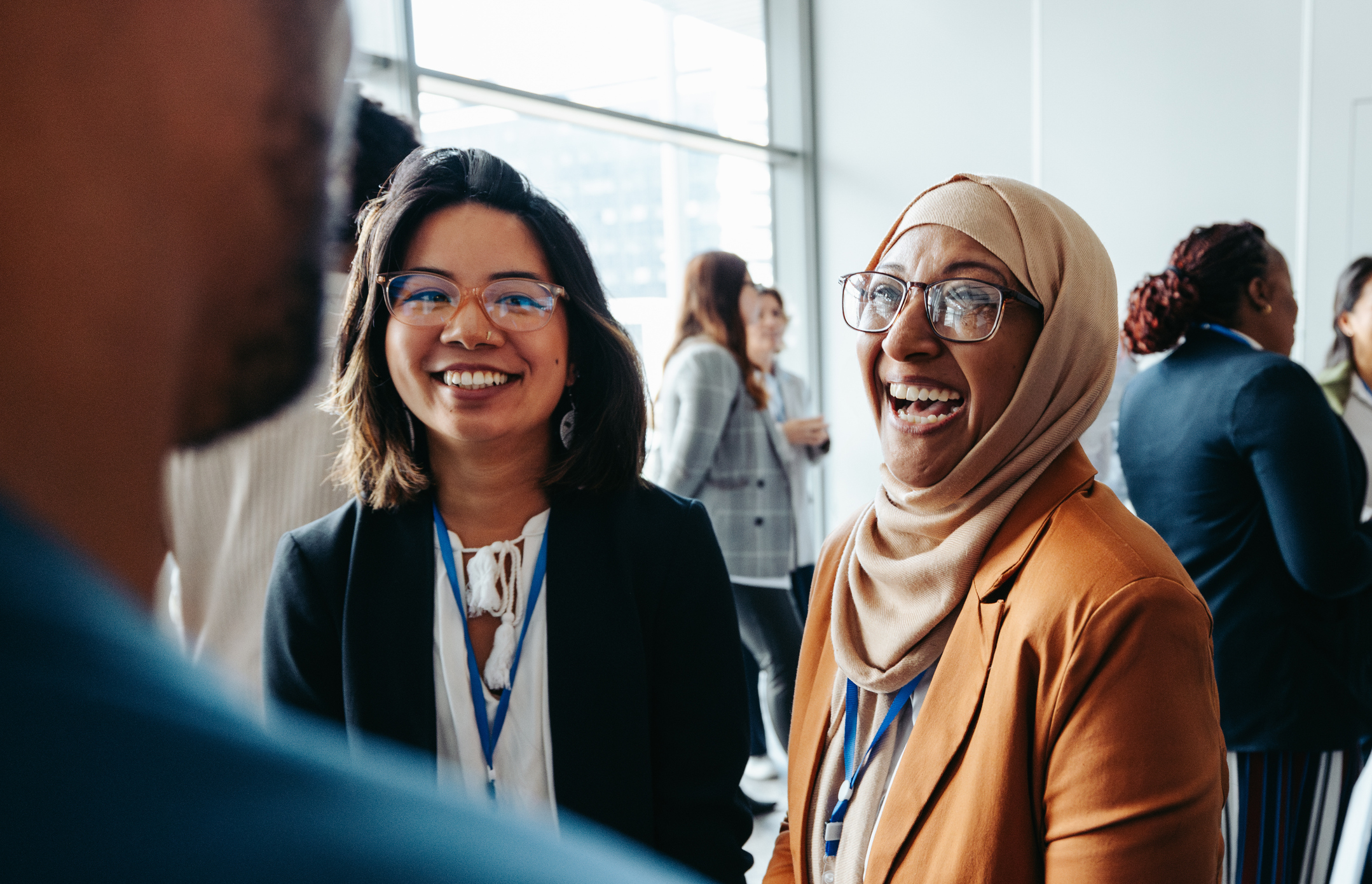 Colleagues smiling mid conversation 