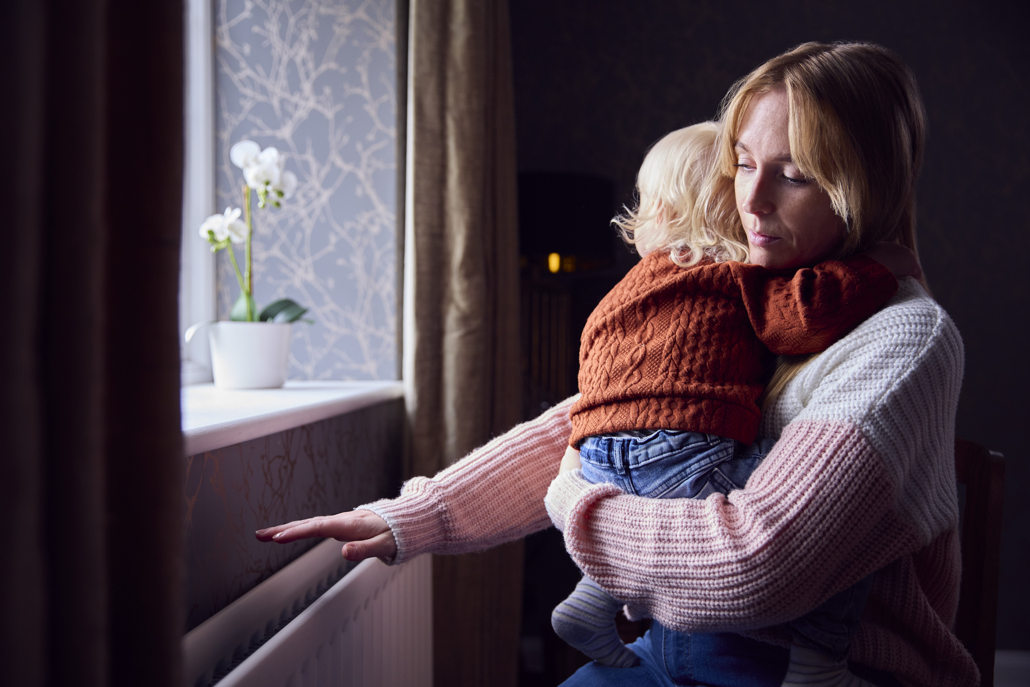 A mother holding her baby in a cold home