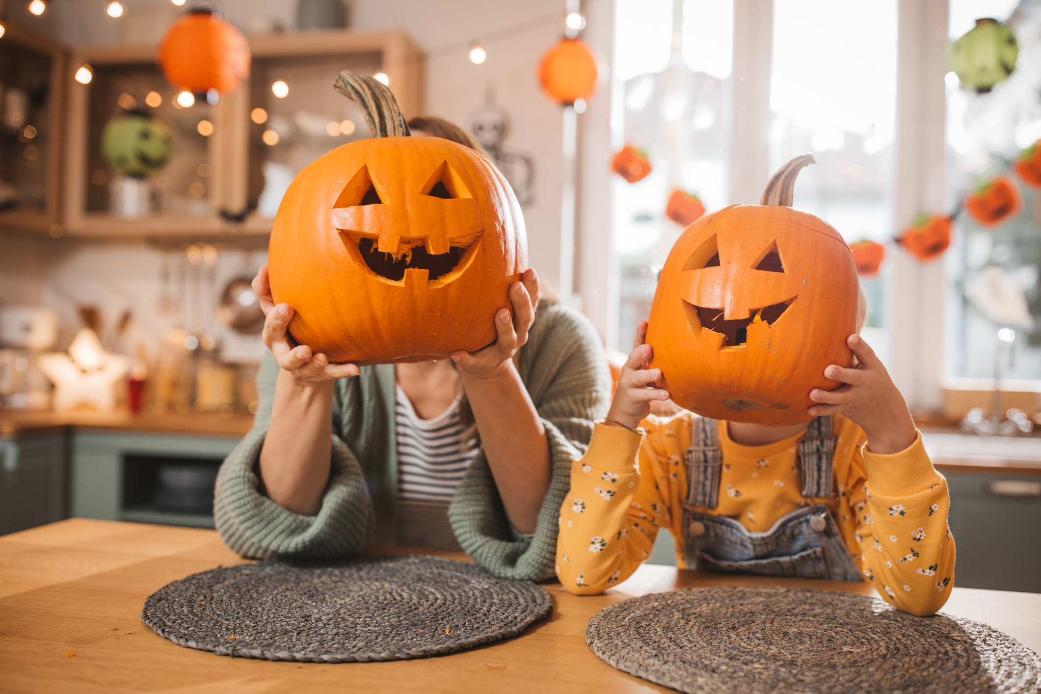 Two children carrying jack-o-lanterns