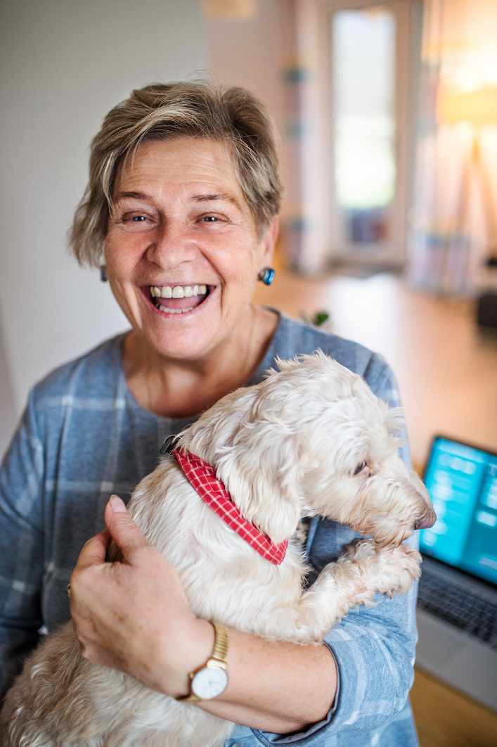 Smiling woman holding her dog