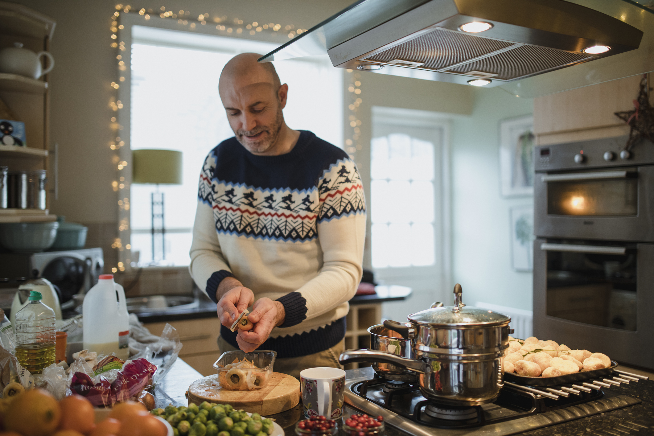 A person wearing a festive jumper is cooking a meal