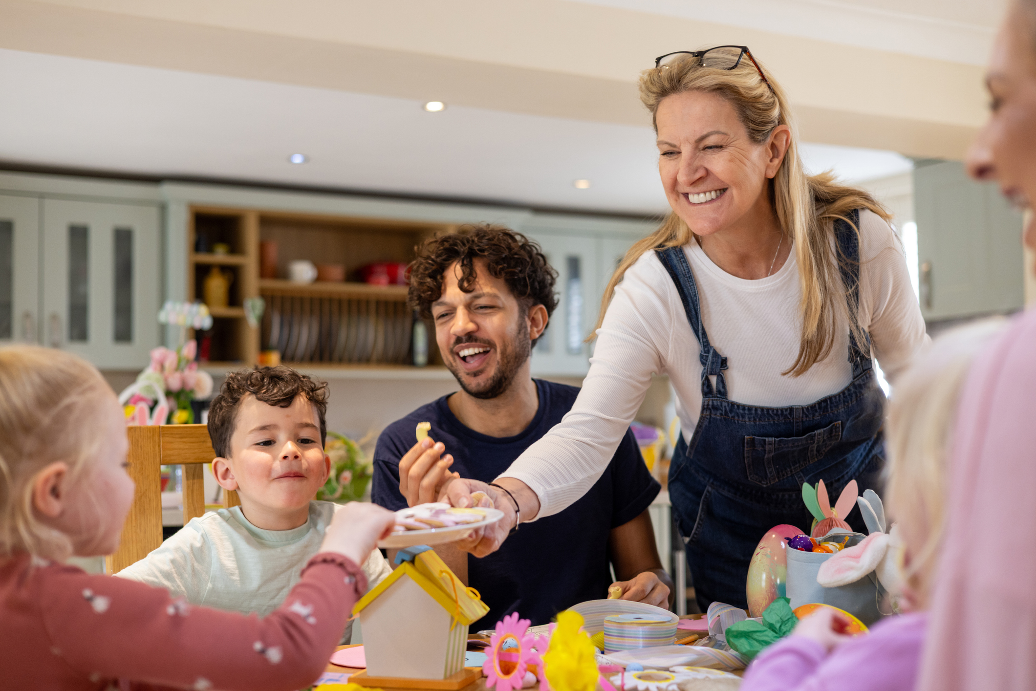 A family sitting around a table and sharing Easter treats. 