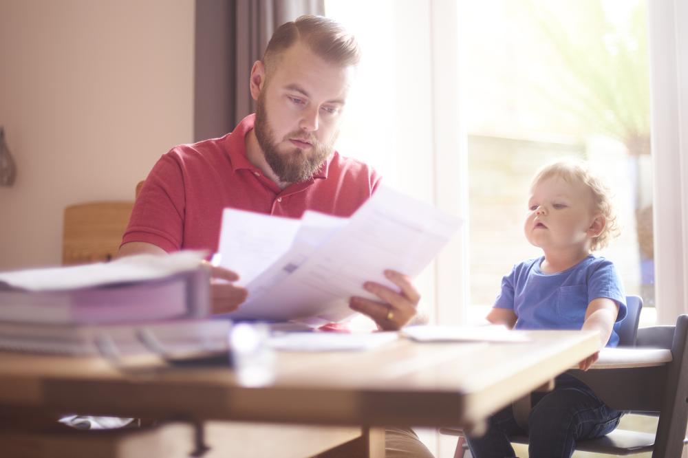 Dad with a child looking at a bill