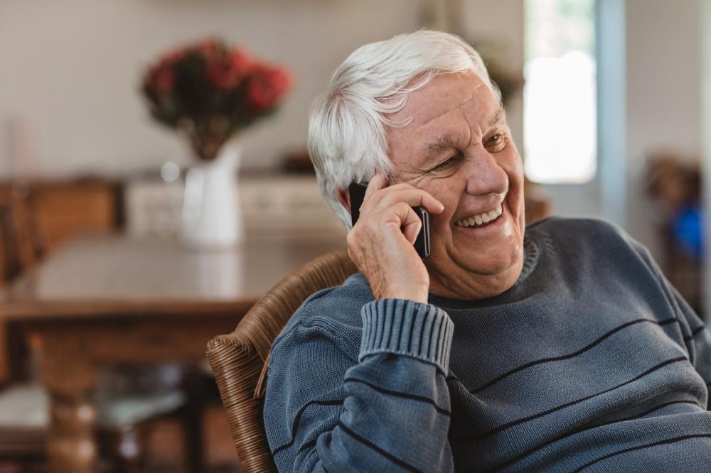 Older man cheerfully talking on his phone