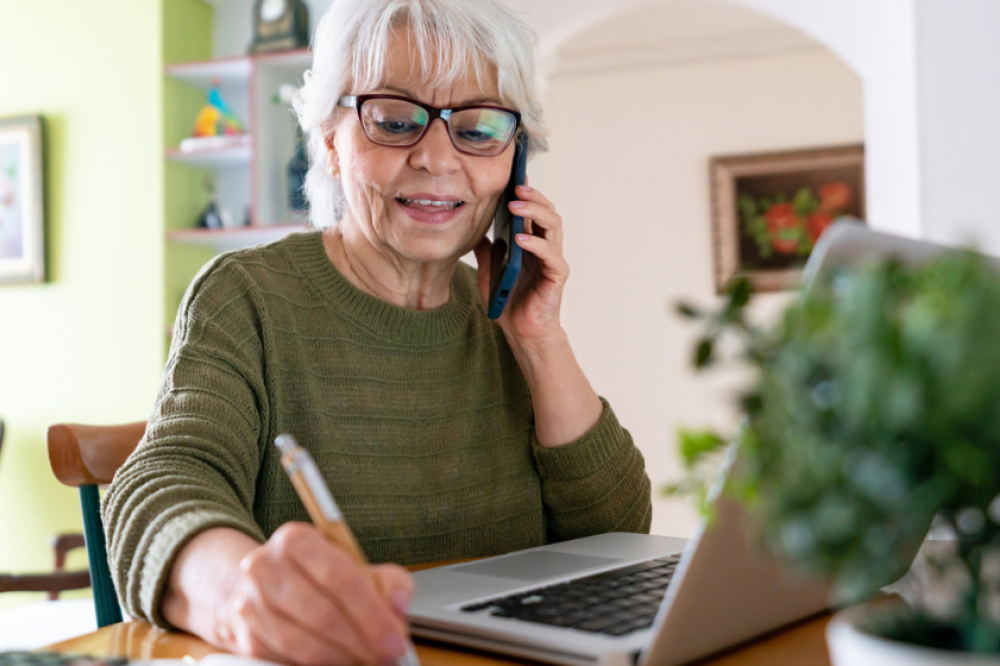 A person using the phone while taking notes
