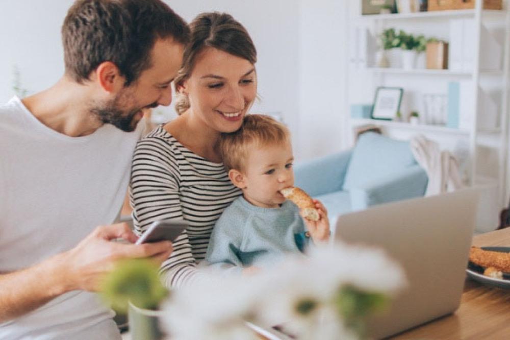 Young family looking at their computer 