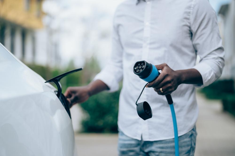 a close up of a man about to charge an electric car