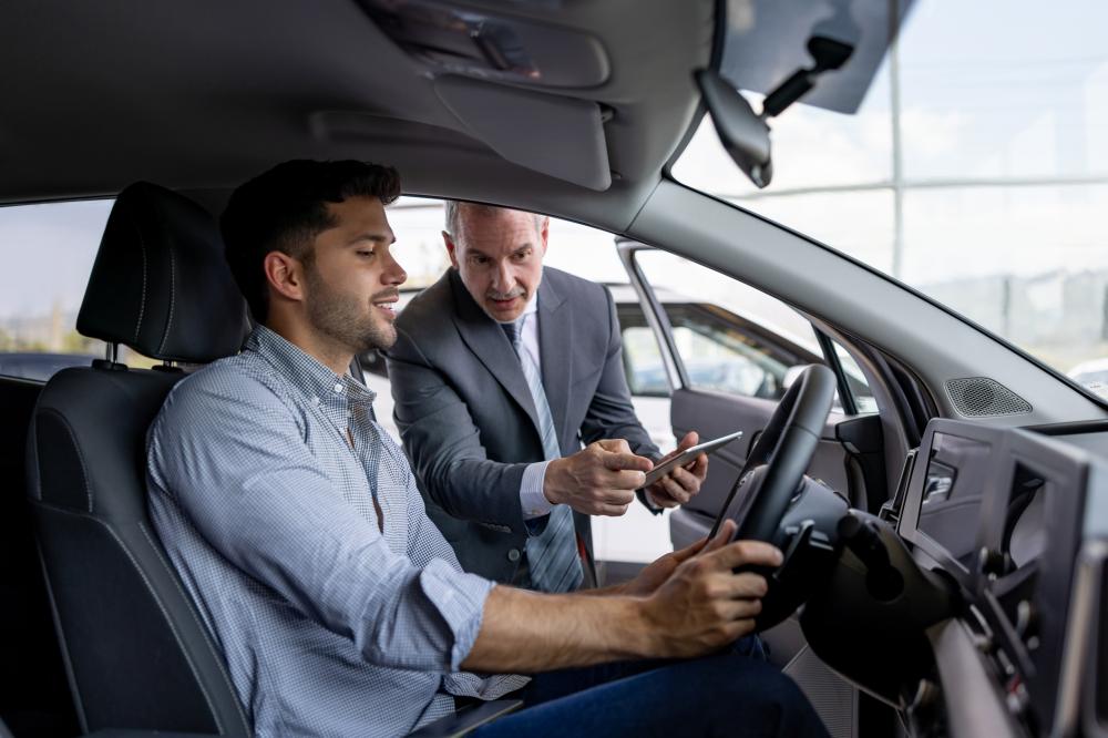 man test driving a car in a dealership