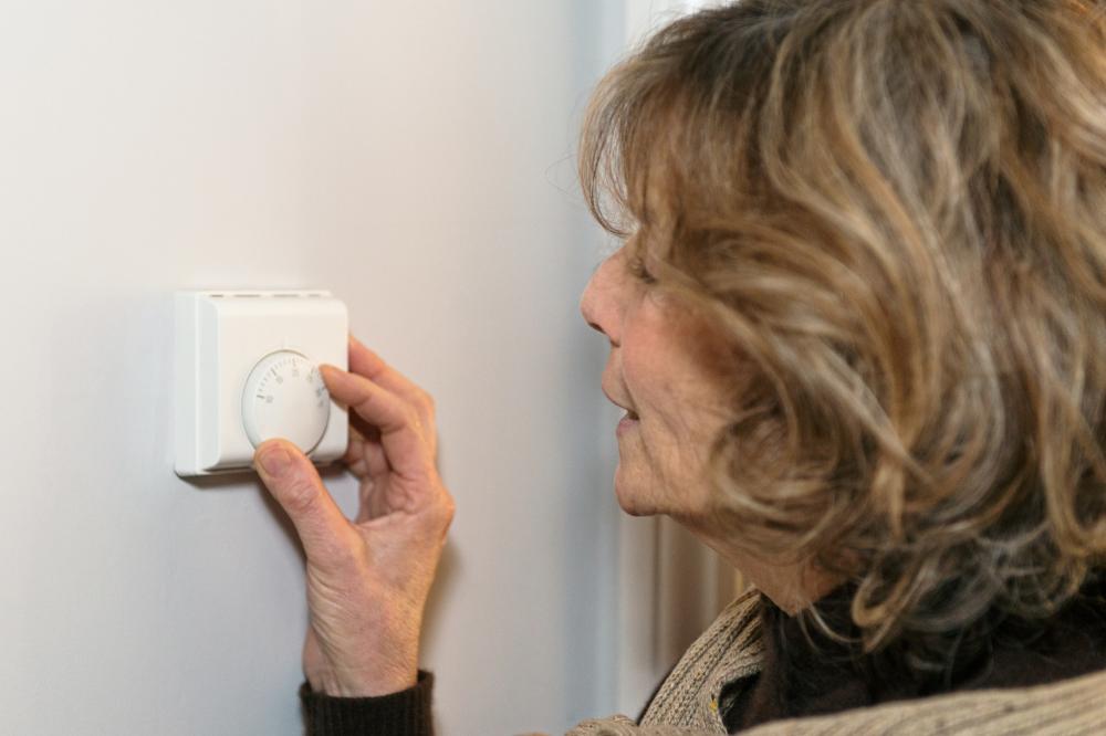 Woman adjusts the heating controls in her house