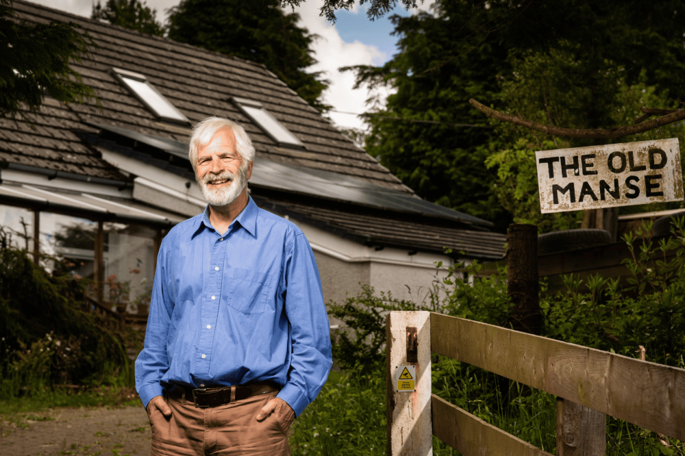 Jim standing in front of his house smiling