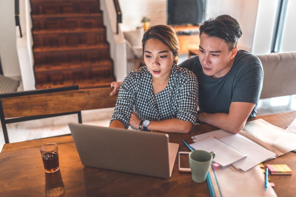 A young couple reading guidance on computer screen