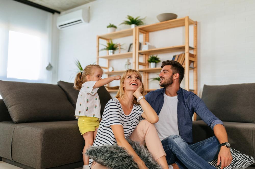 Family sitting in lounge with heat pump in the background