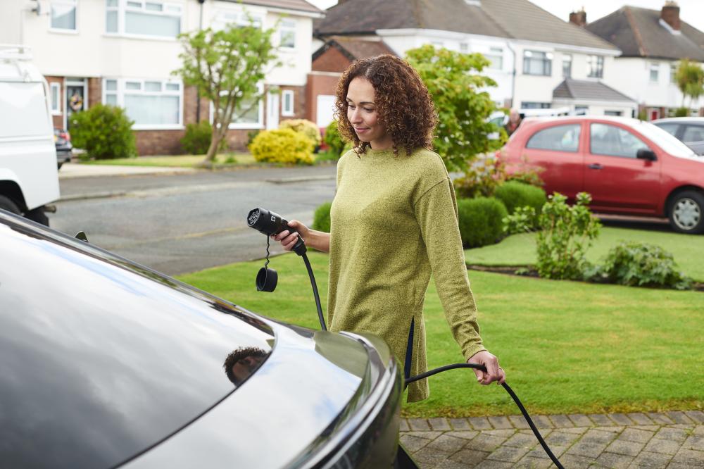A woman charging her car at home
