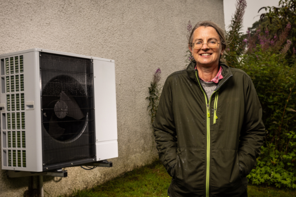 Sally our heat pump hero standing beside her heat pump