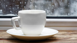 White cup of coffee on a window seal