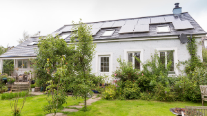 House with solar panels and green garden