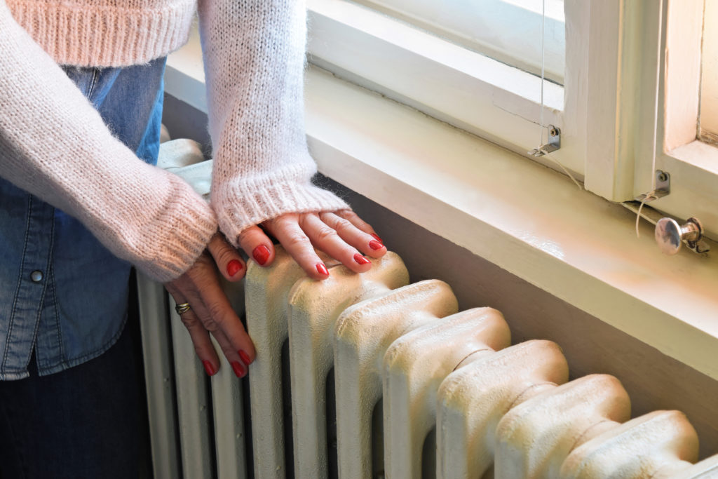 Picture of someone with their hands on a radiator